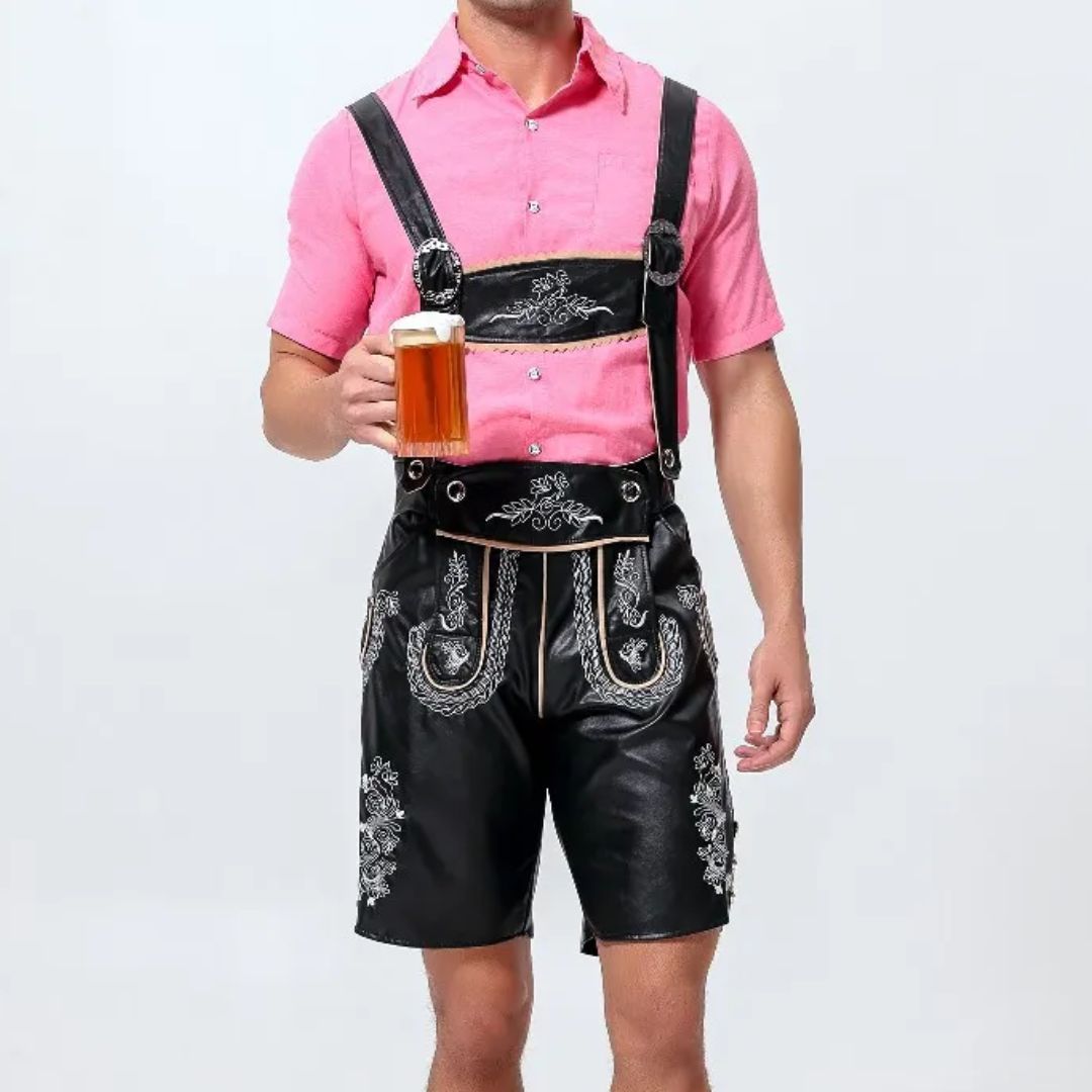 Mann in Lederhose mit rosa Hemd hält Bierkrug, traditionelles bayerisches Outfit.