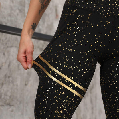 Schwarze Damen-Sportleggings mit goldenen Punkten, elastisch, figurformend, Fitnessmode.