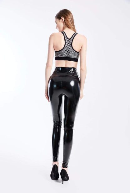Frau in schwarzer glänzender Lederimitat-Leggings und Sport-BH, Rückansicht.