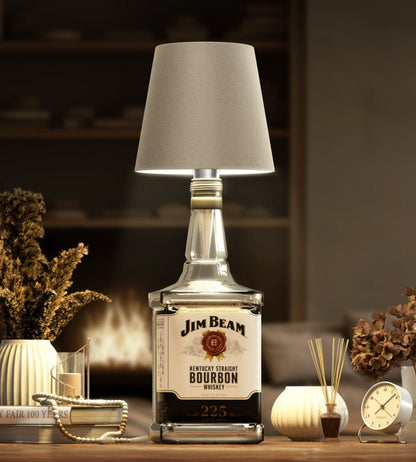 Lampa med beige skärm på en fyrkantig whiskeyflaska, hemtrevligt stylad med torkade blommor, doftpinnar och en klocka. 8