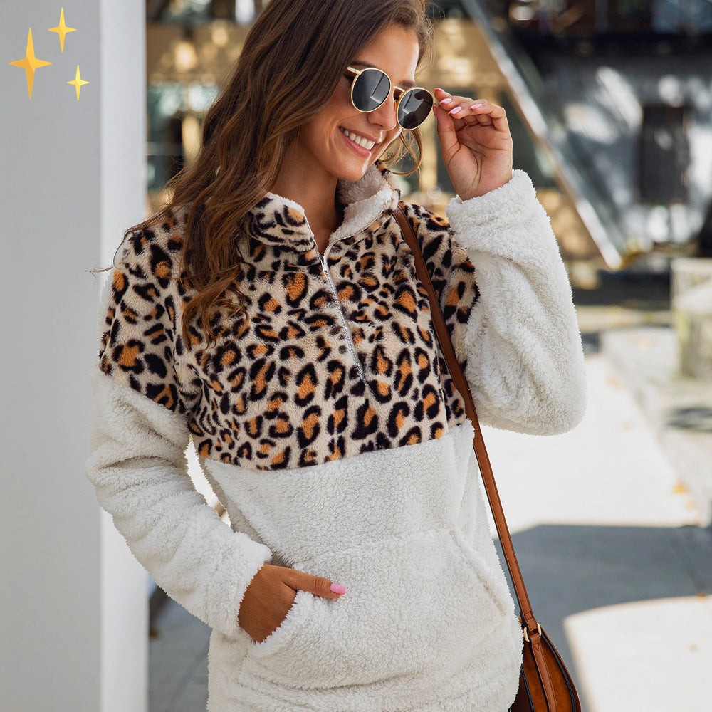 Frau trägt weißen Fleece-Pullover mit Leopardenmuster, Sonnenbrille, Herbstmode.