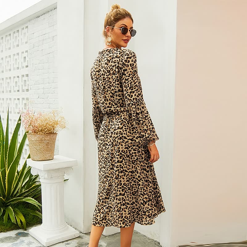 Frau in langem, gepunktetem Leopardenkleid, Sonnenbrille, draußen, modisch, elegant.
