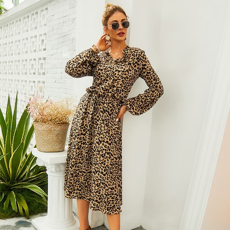 Frau in langem, leopardengemustertem Kleid, Sonnenbrille, draußen, modisch, elegant.