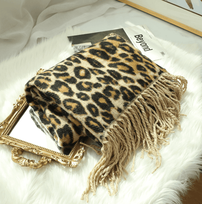 Leopardenmuster Decke mit Fransen auf Spiegel, luxuriöses Wohnaccessoire, weiches Material.