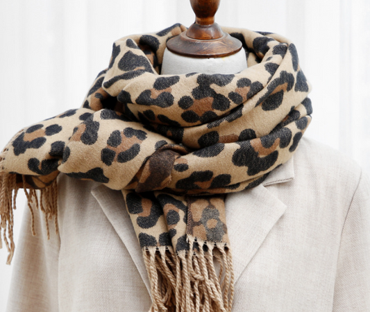 Leopardenmuster Schal aus Wolle, beige und braun, auf beigem Mantel drapiert.
