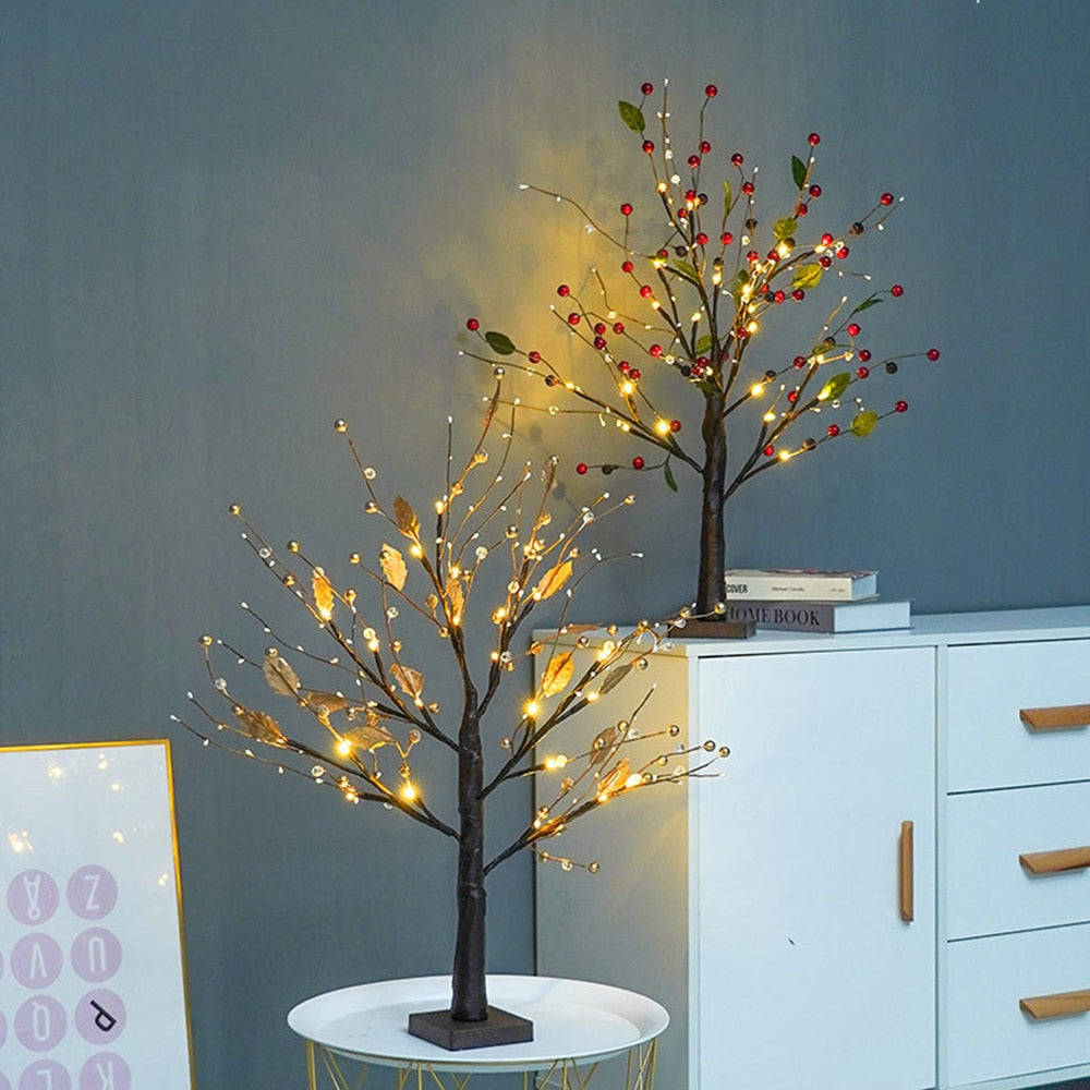 Zwei LED-Baumlichter mit roten Beeren und Blättern auf Tisch, dekorative Beleuchtung.