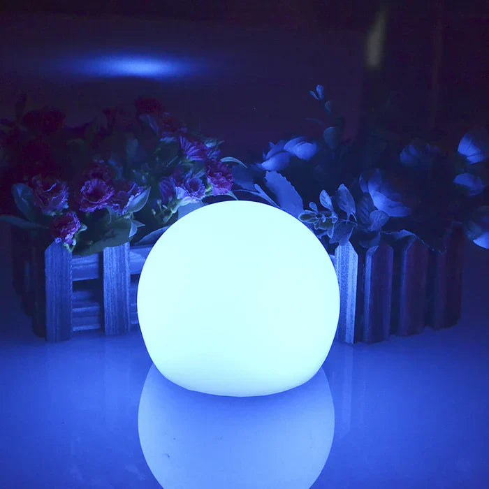 Leuchtende LED-Kugel, weiß, dekorativ, vor Blumenarrangement, stimmungsvolle Beleuchtung