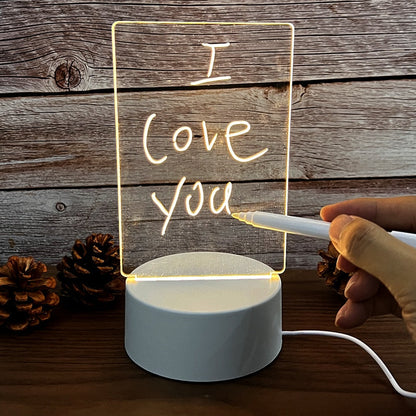 LED-Nachttischlampe mit personalisierbarer Acryltafel, Holzoptik-Hintergrund, Hand schreibt.