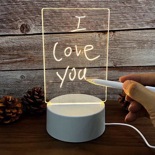 LED-Nachttischlampe mit personalisierbarer Acryltafel, Holzoptik-Hintergrund, Hand schreibt.