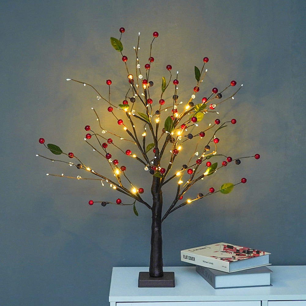 LED-Baum mit roten Beeren und Lichtern auf weißem Tisch, dekorative Beleuchtung.