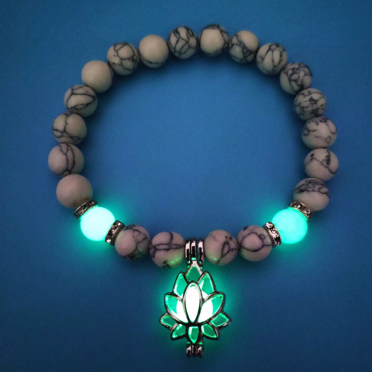Leuchtendes Armband mit Lotus-Anhänger, weiße Perlen, blauem Hintergrund, Schmuck für Damen.