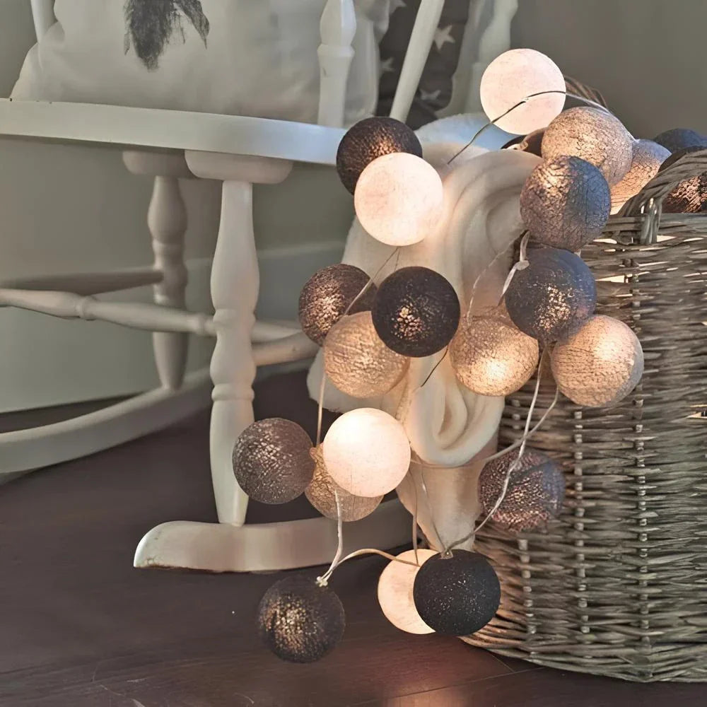 Lichterkette mit weißen und grauen Kugeln, dekorativ, Wohnzimmer, gemütliche Beleuchtung.