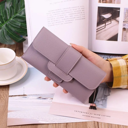 Lila Damen-Geldbörse aus Leder, elegant, modisch, handgehalten, auf Holztisch mit Zeitschrift.