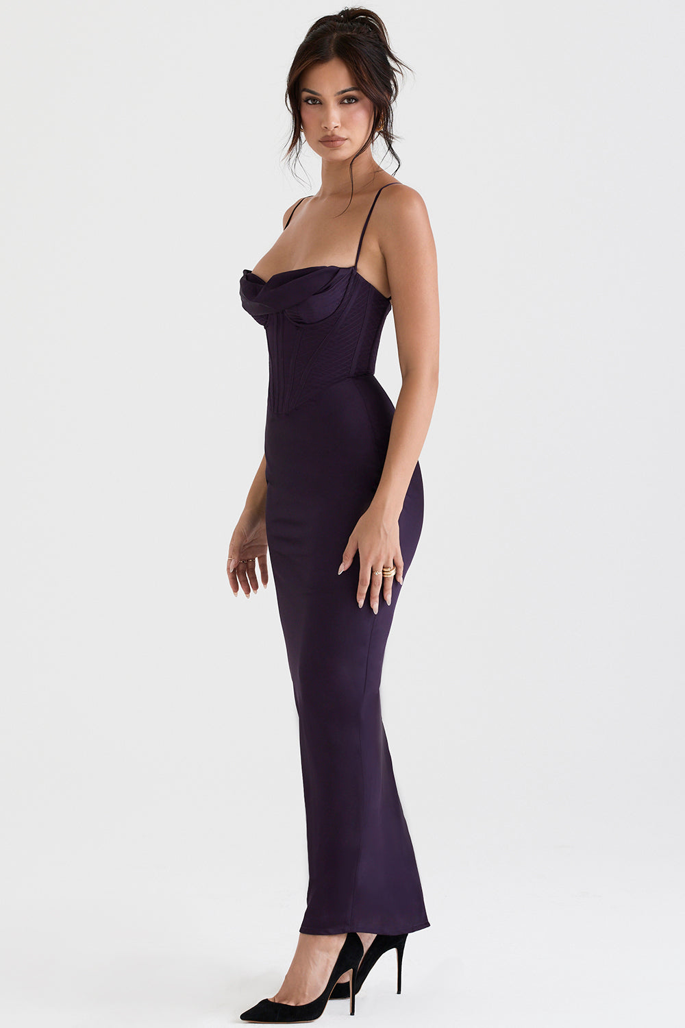 Frau in elegantem, lila Abendkleid mit Spaghettiträgern und schwarzen High Heels.