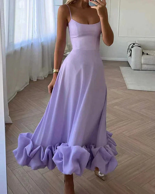 Frau in fliederfarbenem Abendkleid mit Rüschen, elegantes Design, Spaghettiträger.