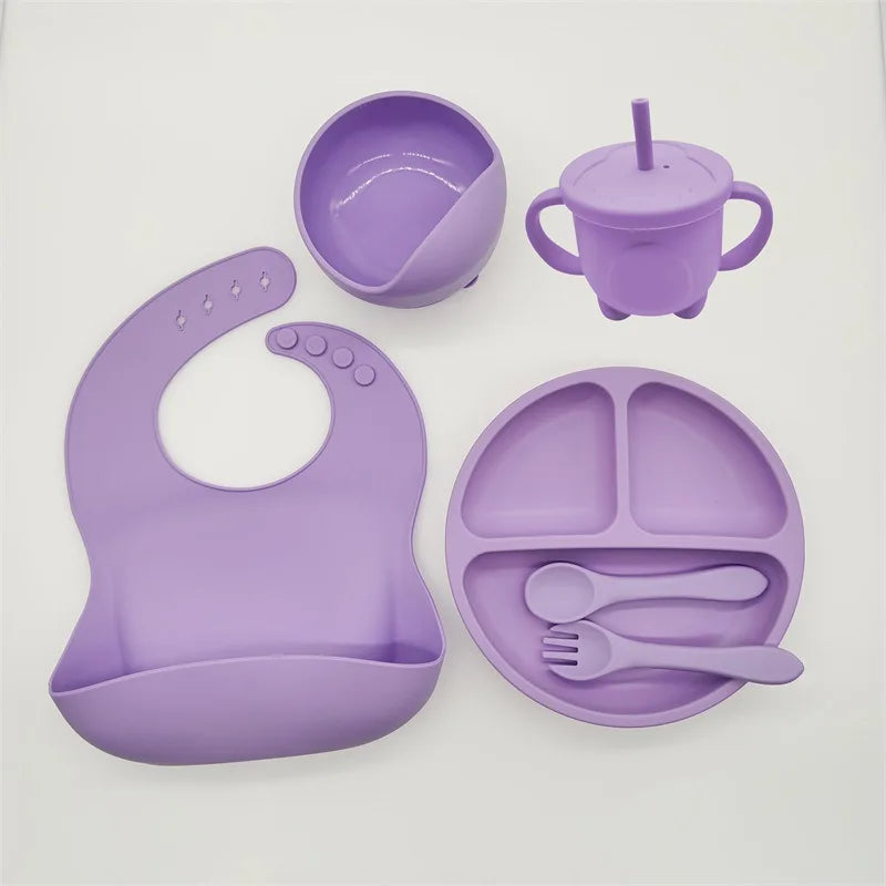 Lila Silikon-Babygeschirr-Set mit Lätzchen, Teller, Schüssel, Becher und Besteck.