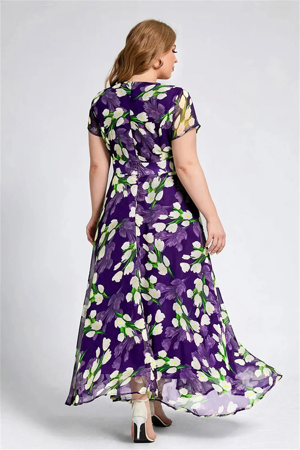 Frau im lila Blumenkleid, knöchellang, kurzärmelig, aus Chiffon, Rückansicht.