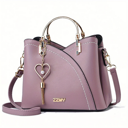 Lila Damenhandtasche aus Leder mit Herzanhänger, goldene Details, Umhängetasche.