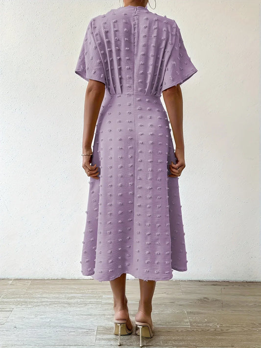 Frau in lila Midikleid mit Punktmuster, Rückansicht, elegantes Design, Sommermode.