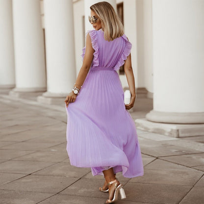 Frau in fliederfarbenem, plissiertem Maxikleid, Sonnenbrille, Sandalen, elegante Mode.