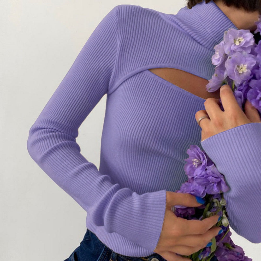 Frau in lila geripptem Pullover mit Blumenstrauß, modisch, elegant, Damenmode.