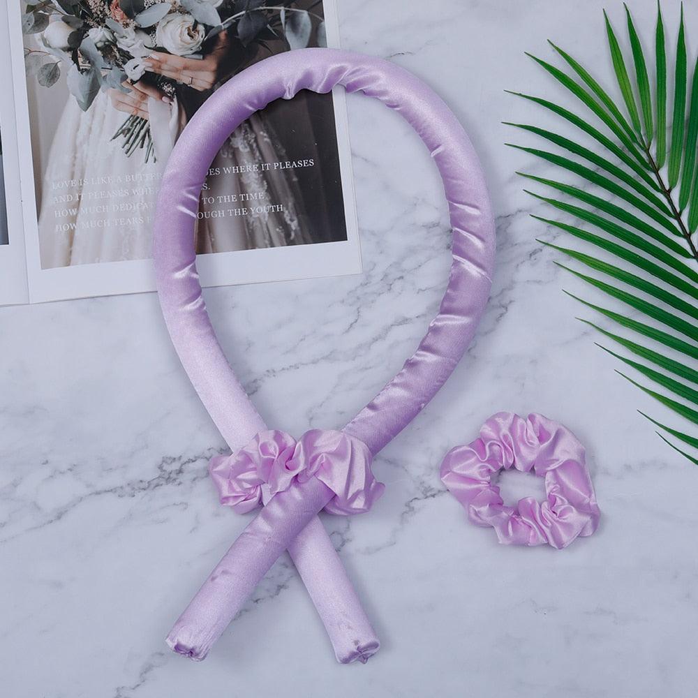 Lila Satin Lockenwickler Set mit Haargummi, hitzefrei, für sanfte Locken, auf grauem Hintergrund.
