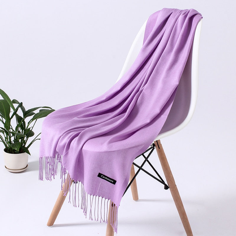 Lila Kaschmirschal auf weißem Stuhl, weiches Material, modisches Accessoire, Wohnzimmerdeko.