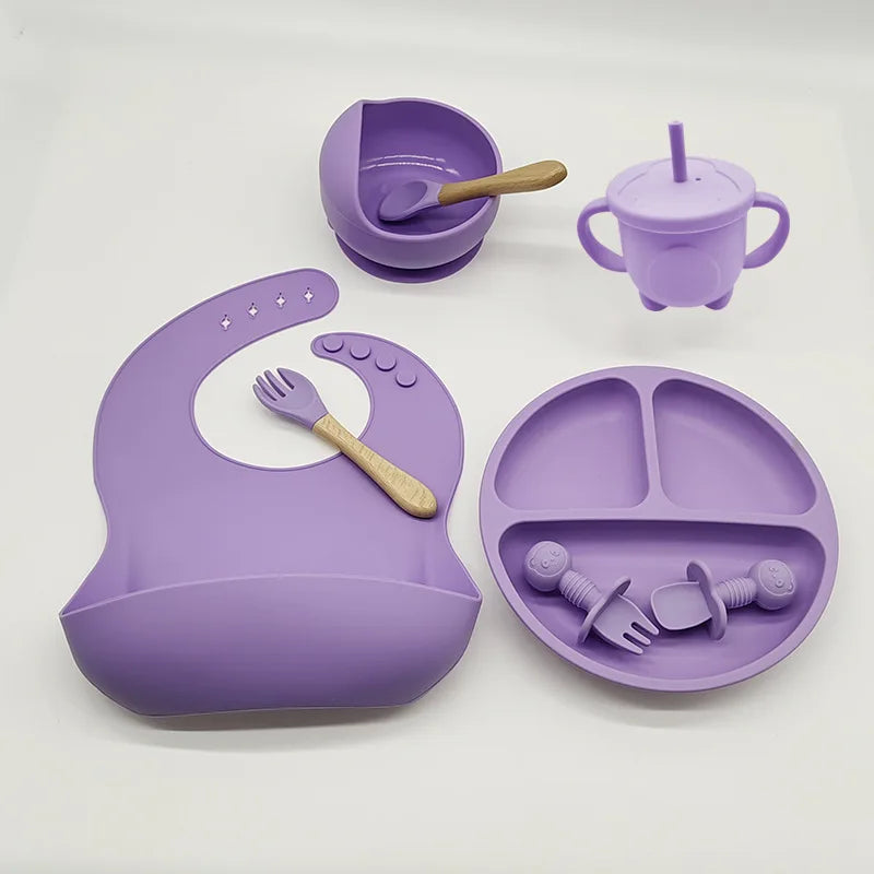 Lila Silikon-Babyteller-Set mit Lätzchen, Becher, Schüssel und Besteck für Kleinkinder.