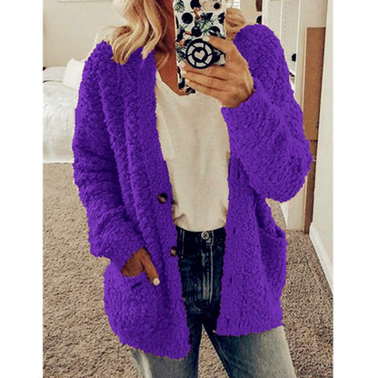 Frau in lila Strickjacke, weißem T-Shirt, Jeans, Smartphone mit gemustertem Case.