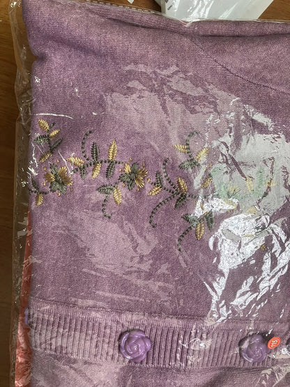 Lila Strickjacke mit Blumenstickerei, Knöpfen, Damenmode, Baumwolle, verpackt in Plastik.