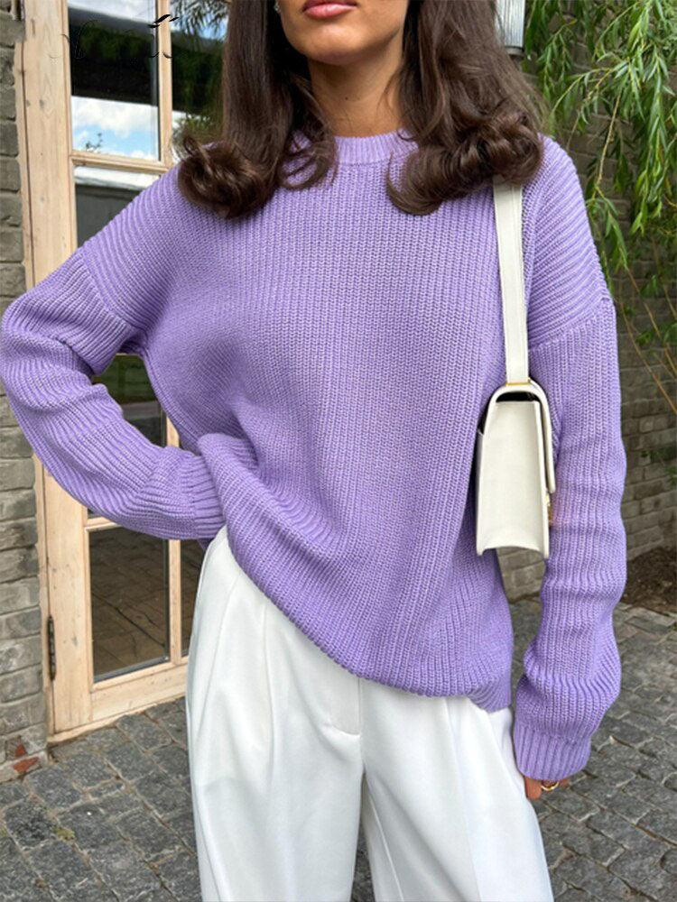 Frau in lila Strickpullover und weißer Hose, modisch, lässig, Herbstmode, draußen.