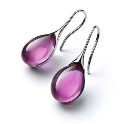 Silberne Ohrringe mit lila Tropfenanhänger, eleganter Schmuck, modisches Accessoire.
