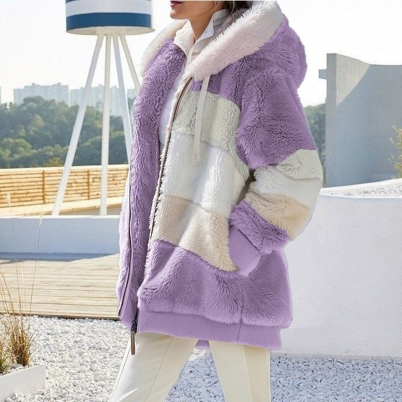 Frau in lila-weißer Plüschjacke mit Kapuze, Wintermode, Outdoor, stilvoll, warm.
