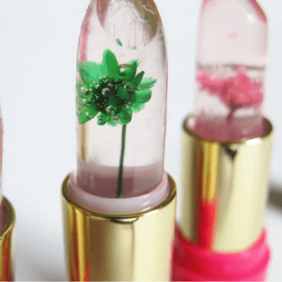Transparenter Lippenstift mit grüner Blume, goldene Hülse, feuchtigkeitsspendend, dekorativ.