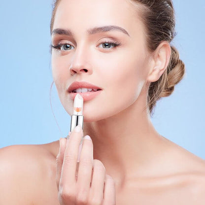 Frau trägt transparenten Lippenstift auf, Beauty-Make-up, natürliche Lippenpflege, blauer Hintergrund.