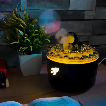 Schwarzer Luftbefeuchter mit gelbem Licht, Dampf, neben Pflanze auf Holztisch.
