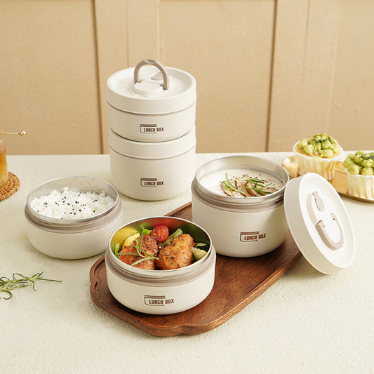 Weiße Bento-Lunchbox aus Kunststoff mit Deckel, gefüllt mit Reis und Gemüse, auf Holztablett.