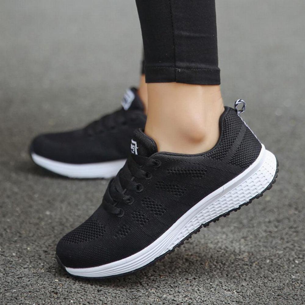 Schwarze Damen-Sneaker aus Mesh, atmungsaktiv, mit weißer Sohle, ideal für Sport und Freizeit.