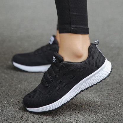 Schwarze Damen-Sneaker aus Mesh, atmungsaktiv, mit weißer Sohle, ideal für Sport und Freizeit.