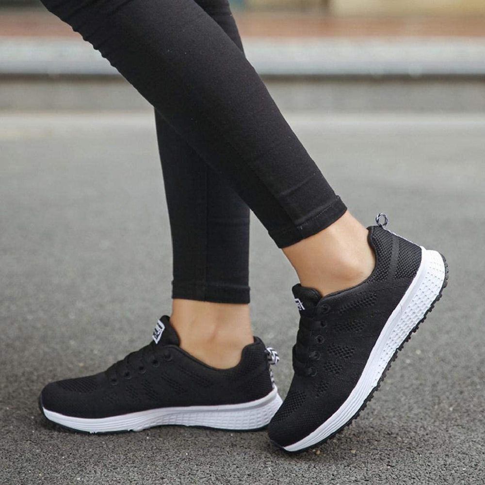 Schwarze Damen-Sneaker, atmungsaktiv, mit weißer Sohle, ideal für Laufen und Freizeit.