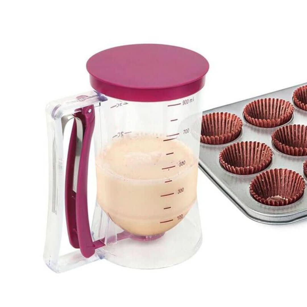 Roter Teigspender aus Kunststoff neben Muffinblech mit Papierförmchen.