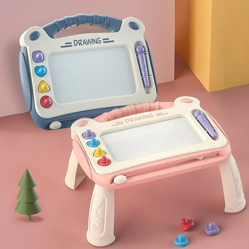 Zwei magnetische Maltafeln für Kinder, blau und rosa, mit Stift und Formen, auf Tisch stehend.