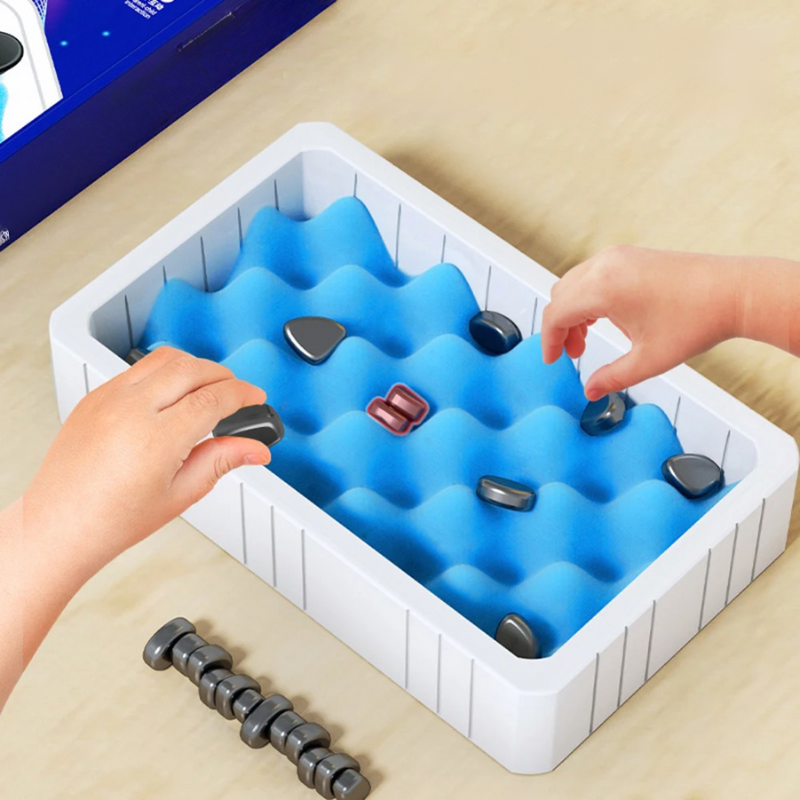 Kinderhandspielzeug mit blauen Wellen, magnetischen Steinen, weißem Tablett, Lernspielzeug.