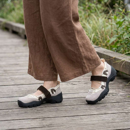 Beige skor med brun rem bärda med vida bruna linnebyxor på en träbro utomhus. 11