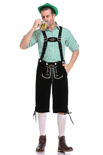 Mann in Lederhose und grünem Trachtenhemd trinkt Bier, Oktoberfest-Outfit, traditionell, bayerisch.