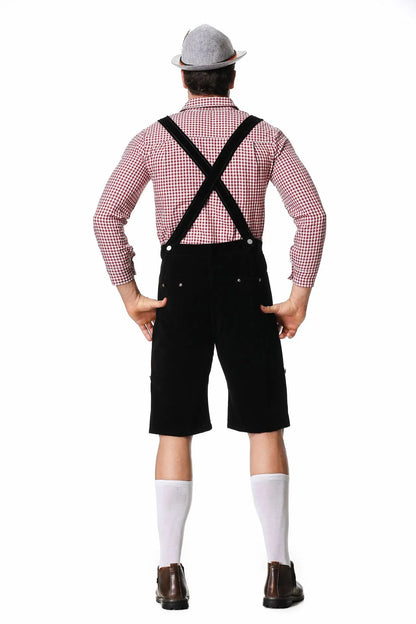Mann in Trachtenmode: Rotes Karohemd, schwarze Lederhose, grauer Hut, weiße Socken, braune Schuhe.