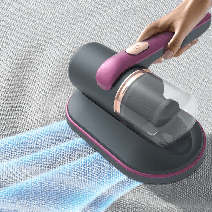 Handstaubsauger grau-rosa, kabellos, auf Teppich, ideal für Hausreinigung, kompakt und effizient.