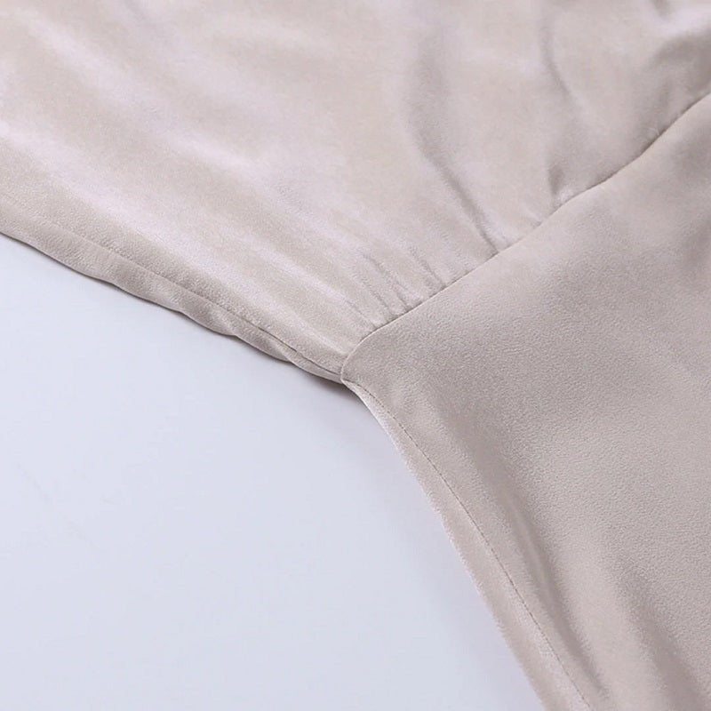 Beigefarbenes Seidenkleid, Nahaufnahme, weicher Stoff, elegante Mode, Damenbekleidung.
