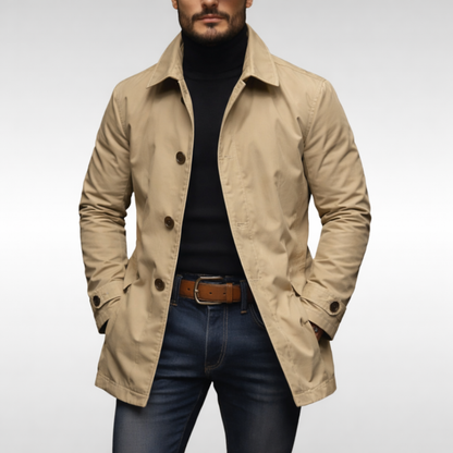 Beige kappa med bruna knappar, buren öppen av en man över svart polotröja och jeans. 5