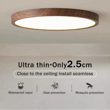 Närbild av tänd lampa med mörk träkant i taket, med symboler för fukt-, damm- och myggskydd. 15
